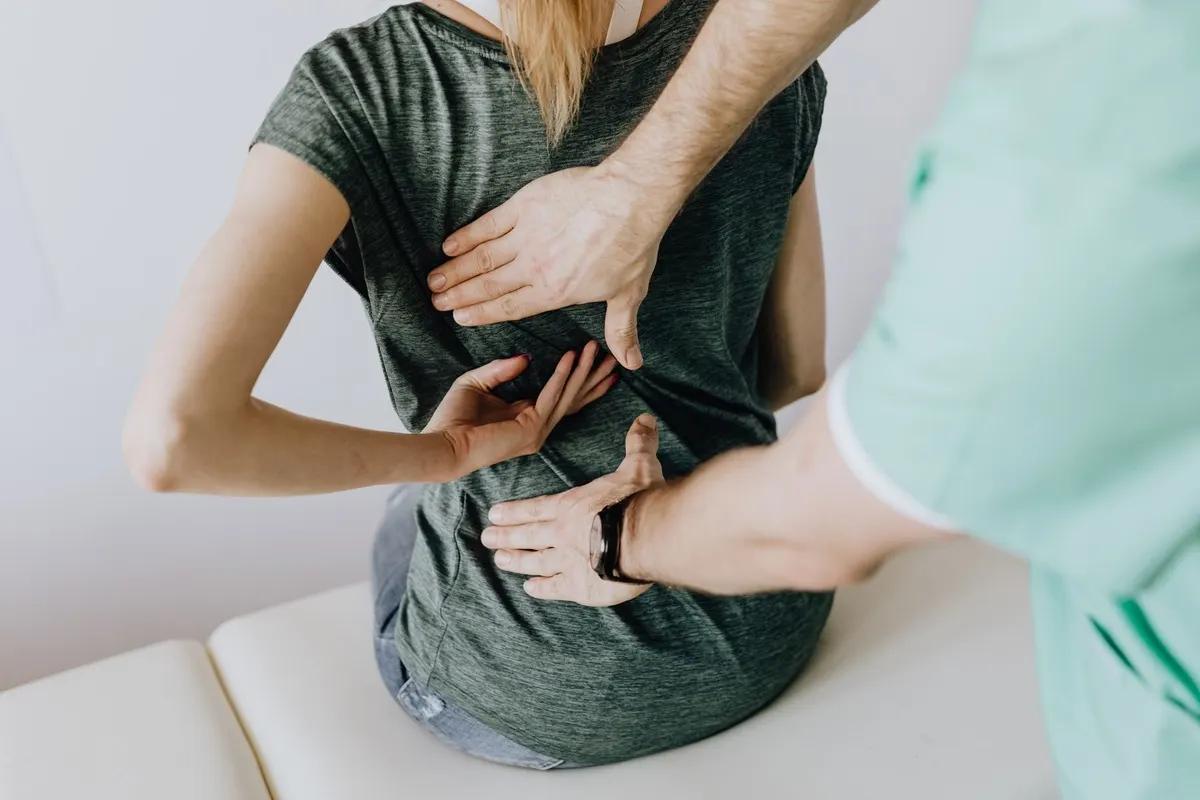 A chiropractor examining a patient's lower back